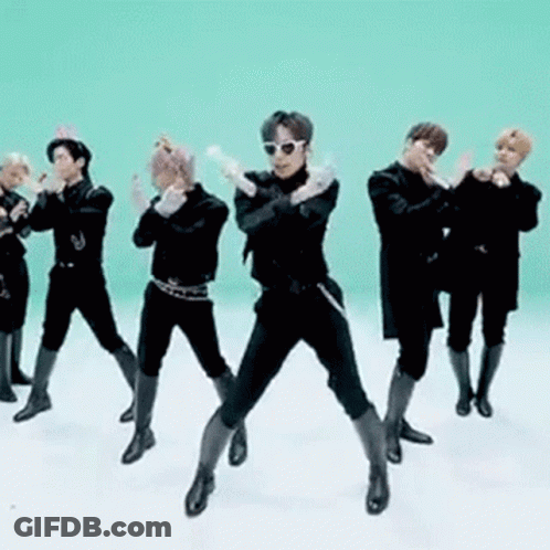 A Group Of Men Are Standing Next To Each Other In A Line And Dancing In Front Of A Green Background . GIF