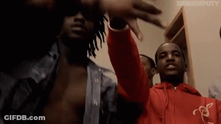 A Group Of Men Are Standing Next To Each Other In A Room . GIF