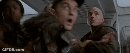 A Group Of Men Are Standing Next To Each Other In A Room And One Of Them Is Holding A Knife . GIF