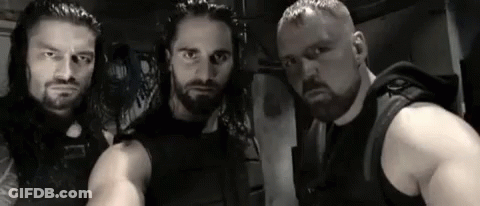 A Group Of Men Are Standing Next To Each Other In A Room . GIF
