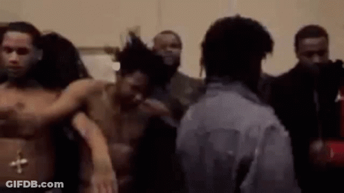 A Group Of Men Are Standing Next To Each Other In A Room Without Shirts . GIF