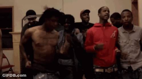 A Group Of Men Are Standing Next To Each Other In A Room Without Shirts . GIF