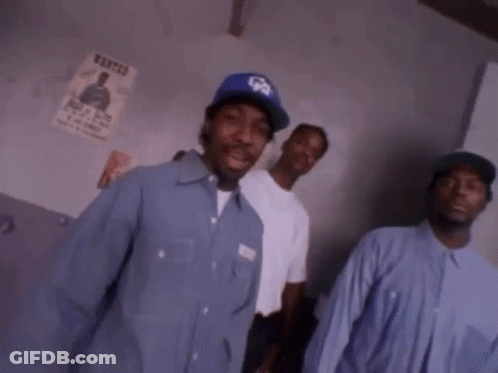 A Group Of Men Are Standing Next To Each Other In A Room . GIF