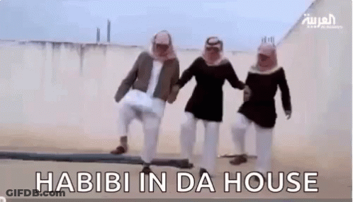 A Group Of Men Are Standing Next To Each Other In The Desert Holding Hands And Dancing . GIF