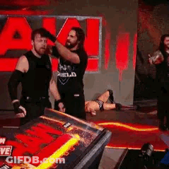 A Group Of Men Are Standing Next To Each Other On A Stage In Front Of A Red Sign . GIF