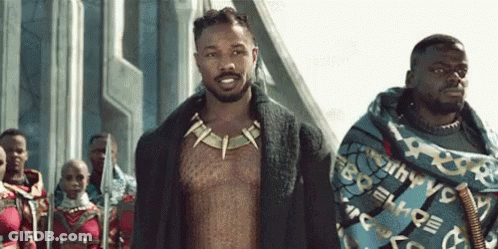 A Group Of Men Are Standing Next To Each Other On A Street . GIF