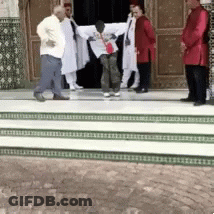 A Group Of Men Are Standing On A Set Of Stairs In Front Of A Building GIF