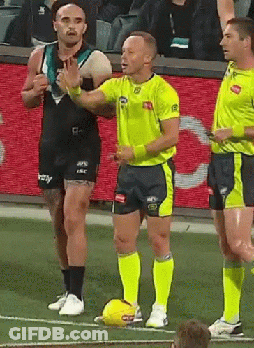 A Group Of Men Are Standing On A Soccer Field With A Referee Holding A Soccer Ball . GIF