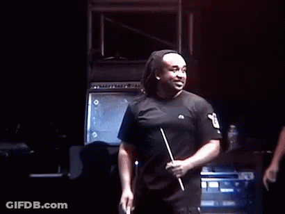 A Group Of Men Are Standing On A Stage And One Of Them Is Wearing A Mask . GIF