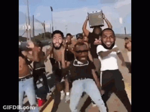 A Group Of Men Are Standing On A Street Holding A Briefcase Over Their Heads . GIF