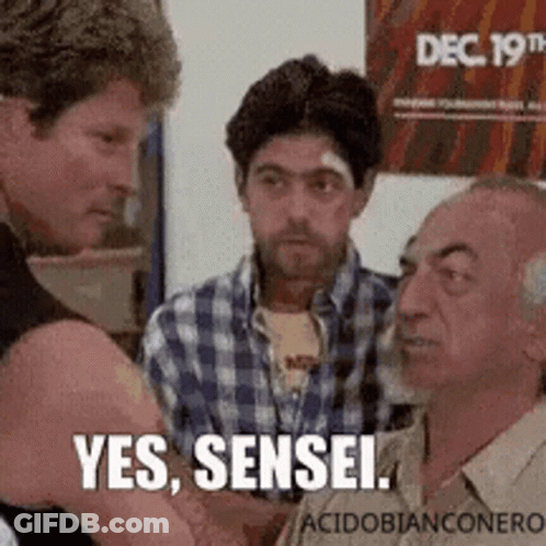 A Group Of Men Are Talking To Each Other And One Of Them Is Holding Another Man 'S Arm . GIF