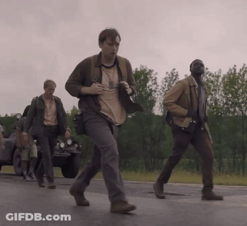 A Group Of Men Are Walking Down A Road And One Of Them Is Wearing A Shirt That Says ' A ' GIF