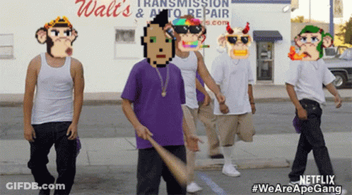 A Group Of Men Are Walking Down A Street In Front Of A Walt 'S Transmission & Auto Repair Shop GIF
