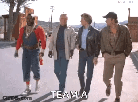 A Group Of Men Are Walking Down A Street With The Words `` Team A '' Written On The Sidewalk . GIF