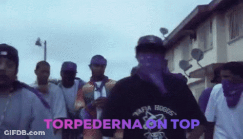 A Group Of Men Are Walking Down A Street With The Words Torpedona On Top In Pink GIF