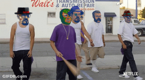 A Group Of Men Are Walking Down The Street In Front Of A Walt 'S Transmission And Auto Repair Store GIF