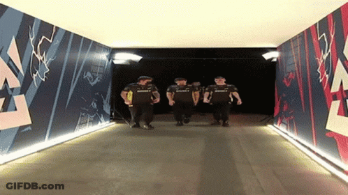 A Group Of Men Are Walking Through A Tunnel That Has A Mural On The Wall That Says Summit GIF