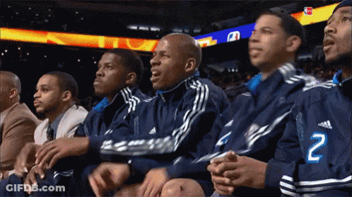 A Group Of Men Are Watching A Basketball Game And One Of Them Has The Number 2 On His Jacket GIF