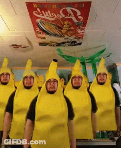 A Group Of Men Dressed As Bananas Are Standing In Front Of A Coca Cola Sign GIF
