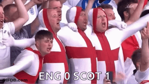 A Group Of Men Dressed As The British Flag Are Standing In A Stadium . GIF