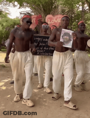 A Group Of Men Holding A Sign That Says Happy Vader GIF