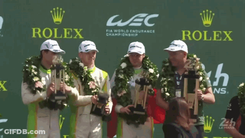 A Group Of Men Holding Trophies In Front Of A Rolex Logo GIF