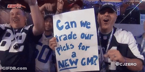 A Group Of Men Holding Up A Sign That Says " Can We Trade Our Picks For A New Gm " GIF