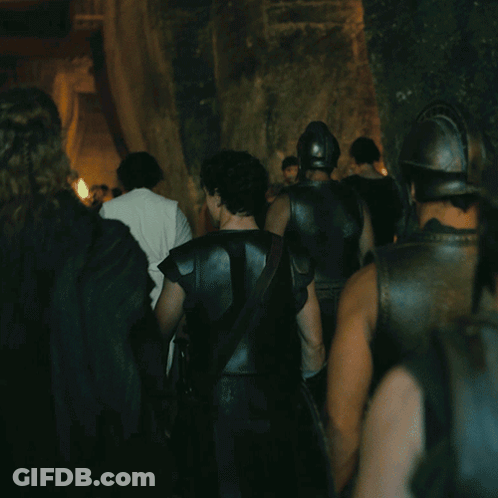 A Group Of Men In Armor Are Walking Through A Dark Room GIF