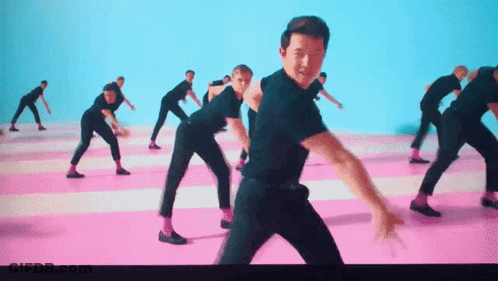 A Group Of Men In Black Shirts And Pink Socks Are Dancing On A Pink And Blue Floor . GIF
