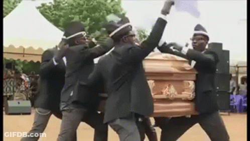 A Group Of Men In Black Suits Are Carrying A Coffin . GIF