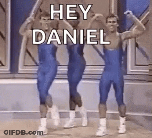 A Group Of Men In Blue Leotards Are Dancing On A Stage And Saying `` Hey Daniel '' . GIF