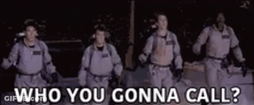 A Group Of Men In Ghostbusters Costumes Are Walking In The Dark And Talking To Each Other . GIF