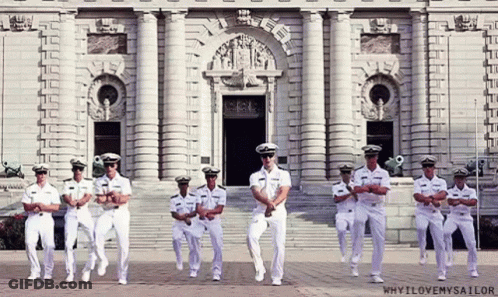 A Group Of Men In Military Uniforms Are Dancing In Front Of A Building That Says Why I Love My Sailor GIF