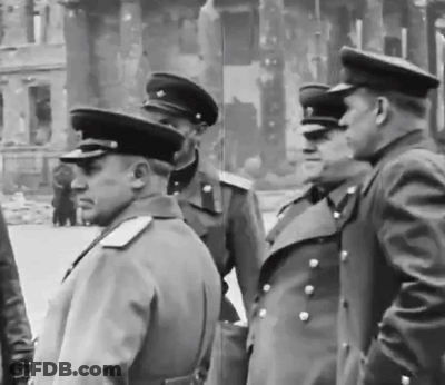 A Group Of Men In Military Uniforms Are Standing In Front Of A Building GIF