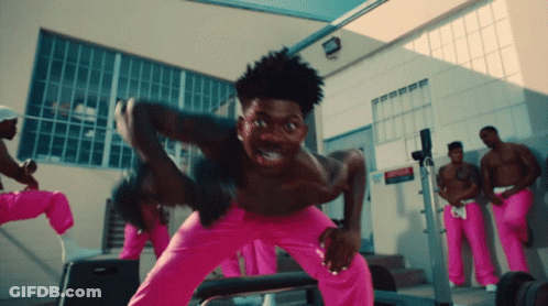 A Group Of Men In Pink Pants Are Standing In Front Of A Building GIF