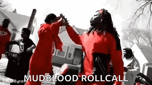 A Group Of Men In Red Jumpsuits Are Dancing In A Black And White Photo . GIF