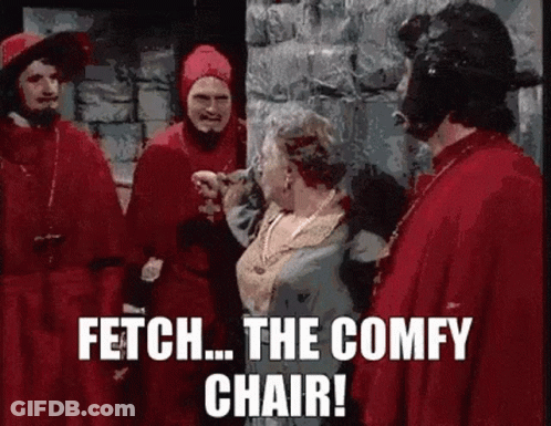 A Group Of Men In Red Robes Are Standing Next To A Woman In A Blue Dress And Talking To Her . GIF