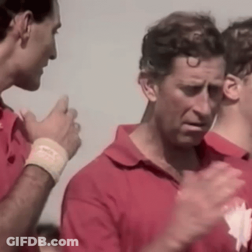 A Group Of Men In Red Shirts Are Standing Next To Each Other Clapping Their Hands . GIF