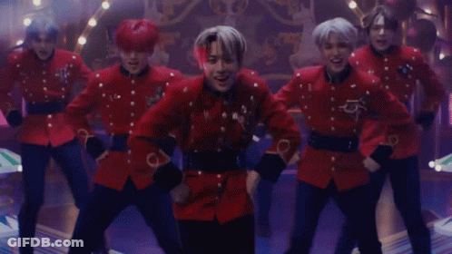 A Group Of Men In Red Uniforms Are Dancing Together GIF