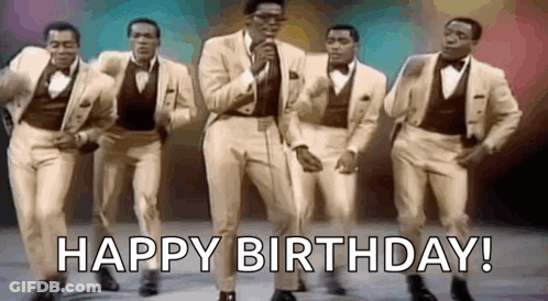 A Group Of Men In Suits And Bow Ties Are Dancing And Singing In Front Of A Microphone . GIF