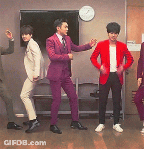 A Group Of Men In Suits And Jackets Are Dancing In Front Of A Clock GIF