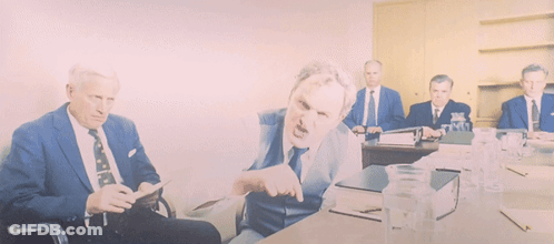 A Group Of Men In Suits And Ties Are Sitting Around A Table With Water Bottles GIF