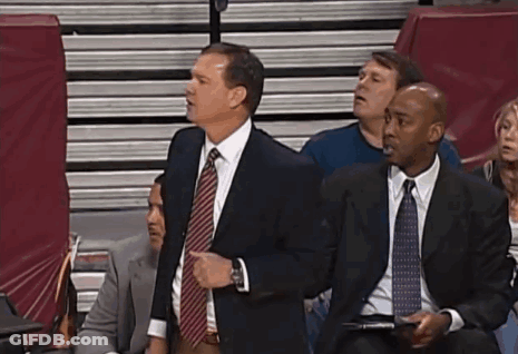 A Group Of Men In Suits And Ties Are Sitting In A Stadium Watching A Game GIF