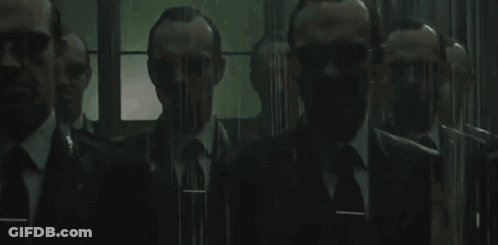 A Group Of Men In Suits And Ties Are Standing Next To Each Other In A Room . GIF