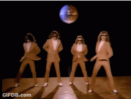 A Group Of Men In Suits And White Gloves Are Dancing In Front Of A Disco Ball . GIF