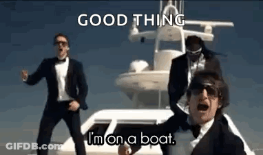 A Group Of Men In Suits Are Dancing On A Boat In Front Of A Yacht . GIF