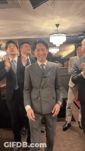 A Group Of Men In Suits Are Dancing Together GIF