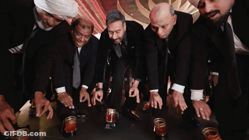 A Group Of Men In Suits Are Kneeling Down With Their Hands On A Table GIF