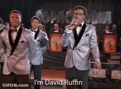 A Group Of Men In Suits Are Standing Next To Each Other On A Stage . GIF