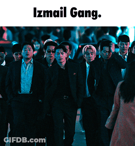 A Group Of Men In Suits Are Walking Down A Street With The Words Izmail Gang Below Them GIF
